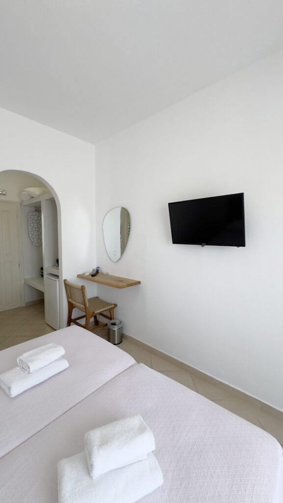 Double or Twin Room with wall-mounted TV, dressing table and flexible bedding configuration at Argo Rooms Antiparos.