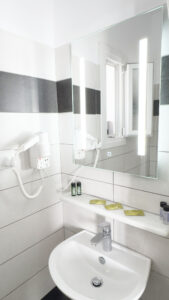 Private bathroom with sink, illuminated mirror, hairdryer and complimentary toiletries in the Studio for 3 Guests at Argo Rooms Antiparos.
